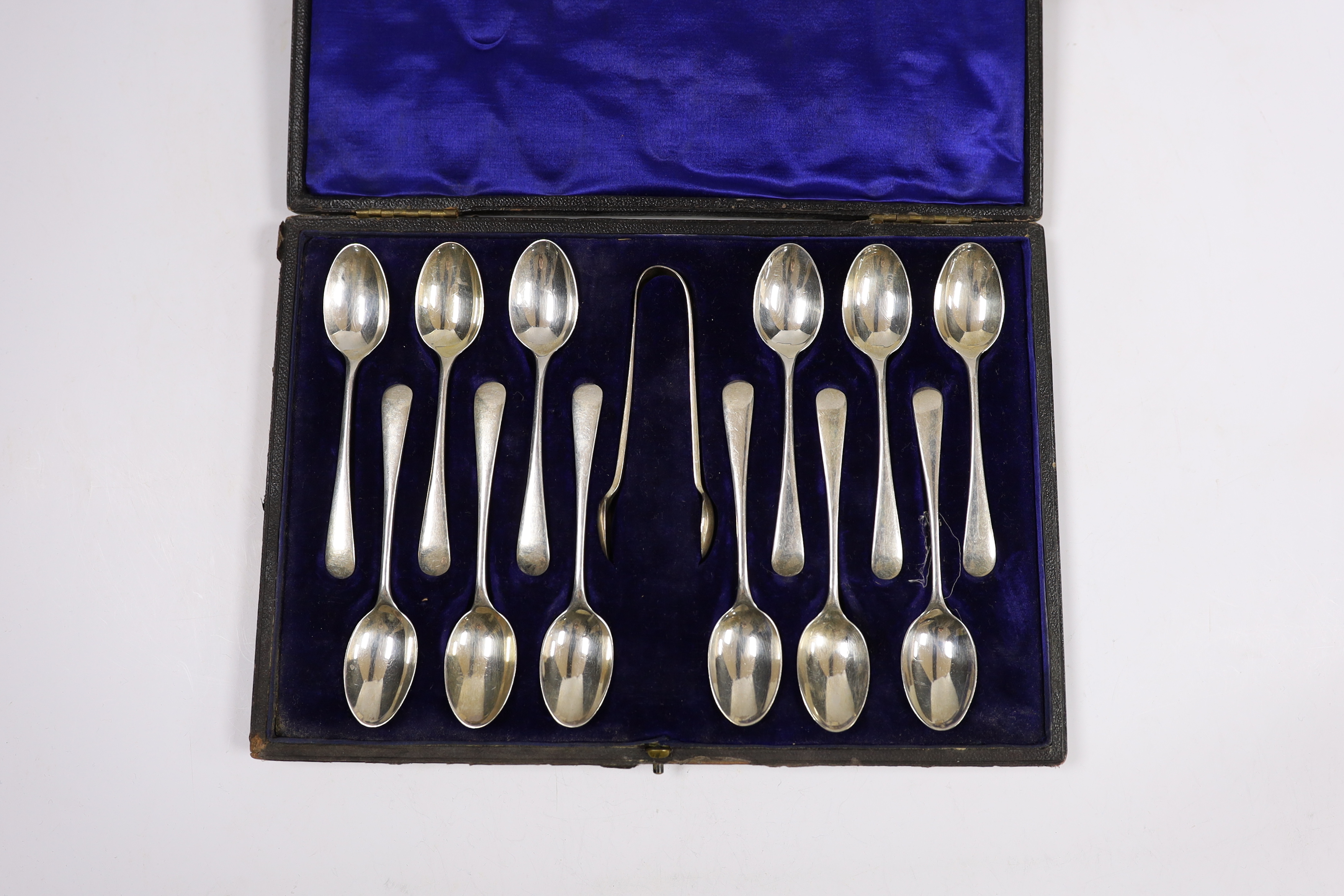 A cased set of twelve Edwardian silver teaspoons with tongs, William Hutton & Sons, London, 1905 and a cased set of five coffee spoons.